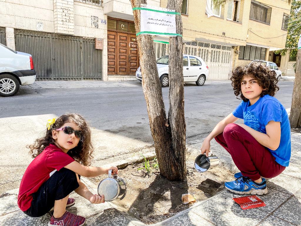 کودک ساکن محله راهنمایی برای سرسبزی محیط اطرافش می‌کوشد