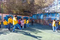 فوتبال خانوادگی در زمین چمن مدرسه محله گلدیس